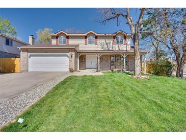 Charming two-story home featuring an attached two-car garage and a well-manicured lawn at 8095 Johnson Ct, Arvada, CO 80005