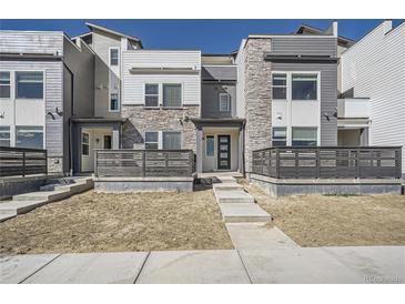 Modern two-story townhome with gray and white exterior, and private fenced yard at 2518 W 69Th Pl, Denver, CO 80221