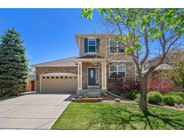 Charming two-story home with stone accents, a well-manicured lawn, and a neatly landscaped front yard at 24738 E Layton Pl, Aurora, CO 80016