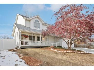 Two-story house with white siding, covered porch, and mature tree in front at 1411 Maple Dr, Berthoud, CO 80513