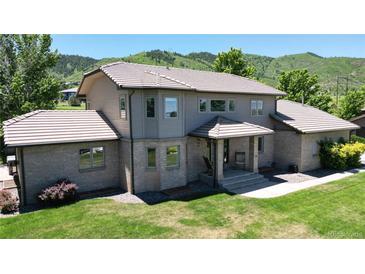 Charming two-story home with a well-maintained lawn and a picturesque mountain backdrop at 10886 Pheasant Run, Littleton, CO 80125