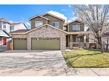 Charming two-story home boasts a stone facade, three-car garage, and inviting front yard at 1788 Alpine Dr, Erie, CO 80516