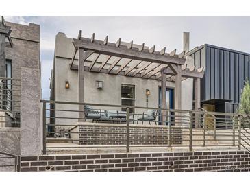 Inviting home exterior with a covered porch, seating, and a charming brick facade at 1819 W 32Nd Ave, Denver, CO 80211