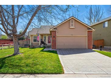 Charming home featuring a well-manicured lawn, brick accents, and a convenient two-car garage at 3303 Blue Grass Cir, Castle Rock, CO 80109