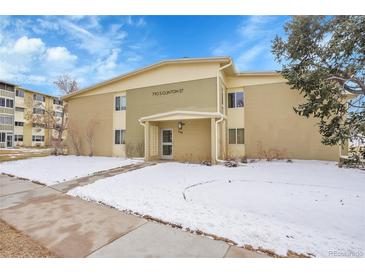 Two-story condo building featuring a well-maintained lawn and snow covered ground at 710 S Clinton St # 6A, Denver, CO 80247