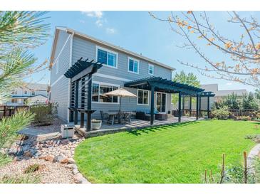 Well-maintained backyard showcasing a pergola, outdoor dining area, and landscaped garden beds for relaxing outdoor living at 7665 Grady Cir, Castle Rock, CO 80108