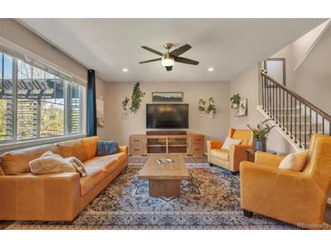 Bright living room features hardwood floors, ceiling fan, and comfortable leather furniture at 7665 Grady Cir, Castle Rock, CO 80108