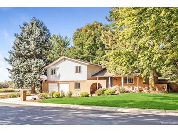 Ranch style home with brick facade, attached garage, and landscaped yard at 2695 S Ammons Way, Lakewood, CO 80227