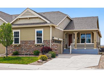 Charming exterior with stone accents, manicured lawn and an inviting front porch at 7426 E 148Th Pl, Thornton, CO 80602