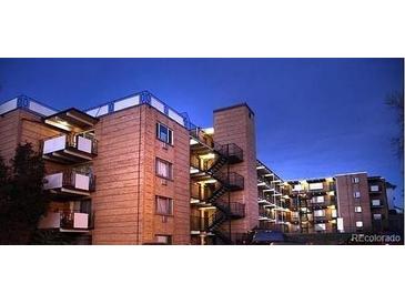 Brick apartment building with multiple levels and balconies at dusk at 800 W Belleview Ave # 407, Englewood, CO 80110