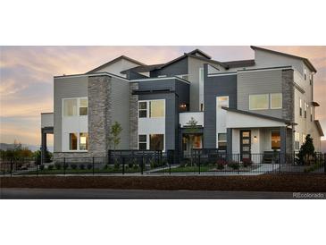 Modern three-story home with stone accents and landscaped yard at 2515 W 69Th Pl, Denver, CO 80221