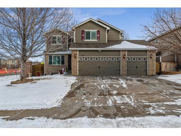 Two-story house with a three-car garage and snow-covered front yard at 2400 S Halifax Way, Aurora, CO 80013