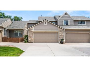 Exterior view of a two-story townhome with a two-car garage and beautiful stone accents at 6664 S Webster St, Littleton, CO 80123