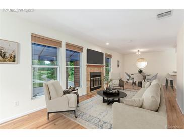 Inviting living room featuring a cozy fireplace, large windows and gorgeous wood flooring throughout at 1030 Jersey St # 1, Denver, CO 80220