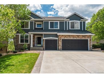 Charming two-story home with stone accents, a well-manicured lawn, and an attached three-car garage at 19105 Eagle Ridge Dr, Golden, CO 80401