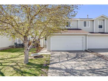 Charming townhome with a two-car garage, beautiful tree, and well-maintained lawn at 5559 S Quemoy Cir, Aurora, CO 80015
