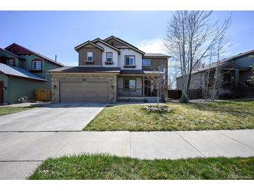 Charming two-story home featuring stone accents, a two-car garage, and a well-maintained front yard at 1386 Avgare Way, Erie, CO 80516