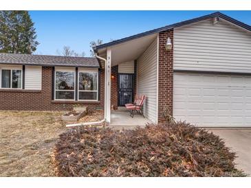 Inviting front porch with brick accents, complemented by a small seating area and well-maintained landscaping at 3161 S Kalispell St, Aurora, CO 80013