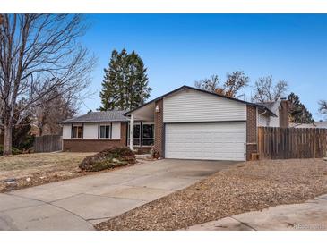 Ranch style home with brick facade, attached garage, and mature landscaping at 3161 S Kalispell St, Aurora, CO 80013