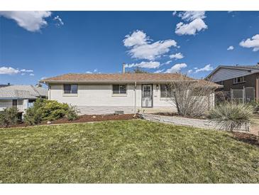 Charming single-story home with a well-maintained lawn, white brick and sunny skies at 1926 S Yates St, Denver, CO 80219