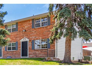 Two-story brick townhouse with a well-maintained lawn and mature trees at 13977 E Bails Pl, Aurora, CO 80012