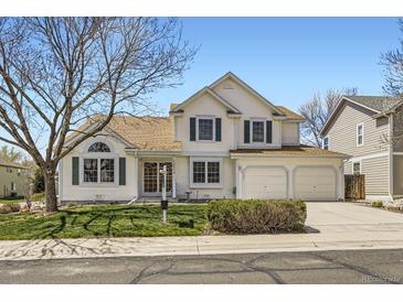 Charming two-story home featuring a three-car garage, green lawn, and beautiful curb appeal on a sunny day at 13515 Milwaukee Ct, Thornton, CO 80241