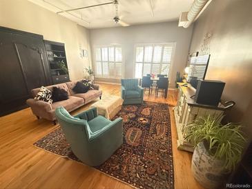 Open living room area with hardwood floors, cozy furniture, and bright natural lighting at 1555 California St # 609, Denver, CO 80202