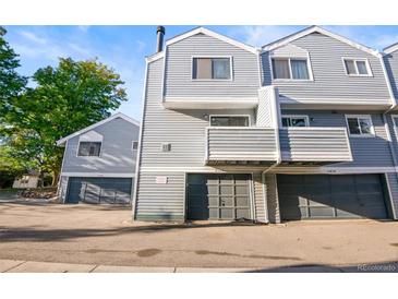 Gray townhome exterior with attached garage and private balcony at 11622 E Cedar Ave, Aurora, CO 80012