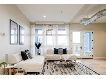 Bright living room featuring neutral decor, modern furnishings, and an eye-catching patterned rug at 3198 Blake St # 402, Denver, CO 80205