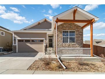 Charming single-Gathering home with stone accents, a covered porch, and a two-car garage at 11482 Colony Loop, Parker, CO 80138