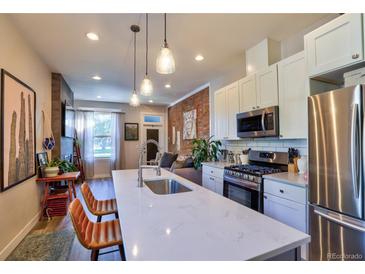 Bright, open kitchen featuring a quartz island, modern appliances, and pendant lighting at 1739 E Martin Luther King Jr Blvd, Denver, CO 80205