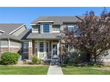 Attractive two-story townhome with stone accents and landscaped front yard at 4727 Raven Run, Broomfield, CO 80023