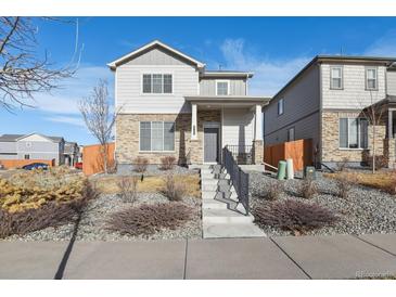 Two-story house with gray siding, stone accents, and a landscaped front yard at 6792 Longpark Dr, Parker, CO 80138