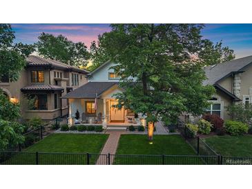Charming home with a manicured lawn, covered porch, and mature trees, showcasing curb appeal at 2340 S Columbine St, Denver, CO 80210