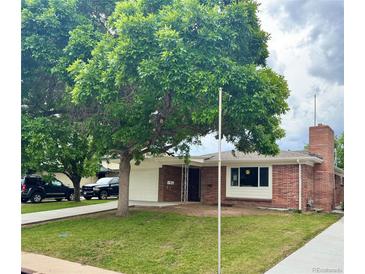 Charming brick home with a well-manicured lawn, mature trees, and an attached one-car garage at 1815 S Monroe St, Denver, CO 80210