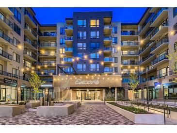 Modern apartment complex featuring string lights and brick facade at twilight at 20 Wilcox # 421, Castle Rock, CO 80104