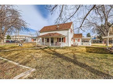 Charming two-story home with a quaint front porch and red shutters, perfect curb appeal at 5300 Balsam St, Arvada, CO 80002