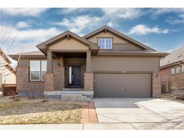 Inviting two-story home with brick accents, covered porch, and attached two-car garage at 6284 N Genoa Way, Aurora, CO 80019