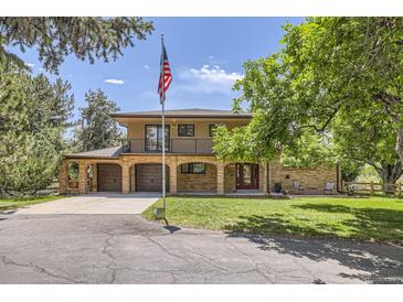 Charming two-story home with brick facade, balcony, spacious driveway, and attached two-car garage at 12196 W Belleview Dr, Littleton, CO 80127