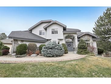 Charming two-story home features stone accents, an attached garage, and a well-manicured lawn at 2247 Eagles Nest Dr, Lafayette, CO 80026