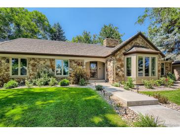 Charming stone home with a tile roof, mature landscaping, and a well-manicured lawn on a sunny day at 13 Club Ln, Littleton, CO 80123