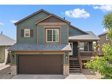 Inviting two-story home featuring a covered porch and a two-car garage, perfect for families at 9698 Queenscliffe Dr, Highlands Ranch, CO 80130