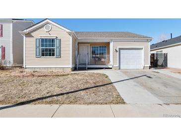Charming single-story home with a front yard, a small porch, an attached garage, and light beige siding at 15627 E 51St Dr, Denver, CO 80239