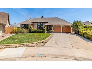 Charming home with a well-manicured lawn, large driveway, and attached two-car garage at 5448 S Swadley Ct, Littleton, CO 80127