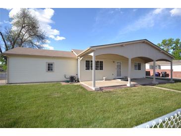 Exterior shot of backyard with covered patio and lawn at 2685 W Asbury Ave, Denver, CO 80219