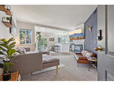 Bright, open-concept living room with modern gray sofa, fireplace, and flat-screen TV at 6850 Xavier Cir # 5, Westminster, CO 80030