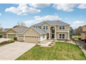 Beautiful two-story home with a three car garage and manicured front yard at 12110 Bay Oaks Ct, Parker, CO 80138