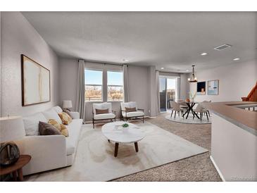 Open-concept living room features a white sofa, natural light, and a marble top coffee table at 17359 Waterhouse Cir # C, Parker, CO 80134
