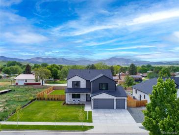Stunning home exterior with modern design, a well-manicured lawn, and mountain views at 3343 S Newcombe St, Lakewood, CO 80227