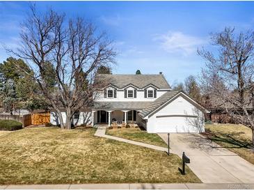 Charming two-story home with a well-manicured lawn, inviting front porch, and attached two-car garage at 10385 E Ida Ave, Greenwood Village, CO 80111